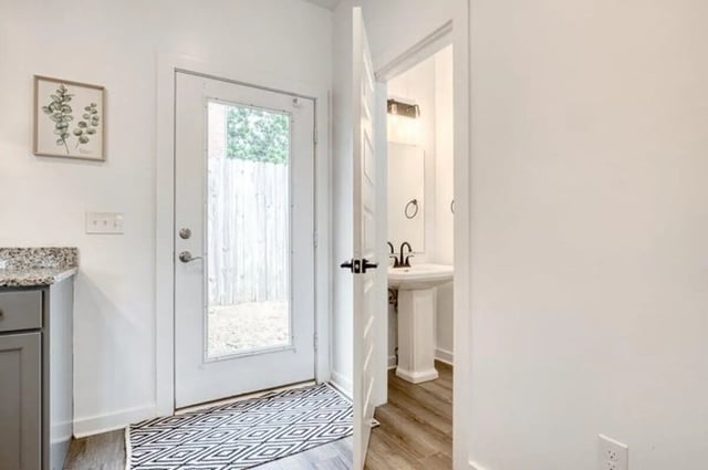 Door rug with open bathroom door and sink at Haven Blacksburg in Blacksburg Student Accommodation