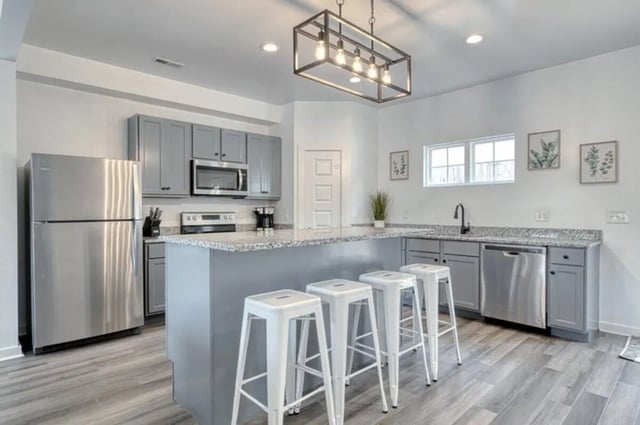 Stainless steel appliances bar stools and island kitchen at Haven Blacksburg in Blacksburg Student Accommodation