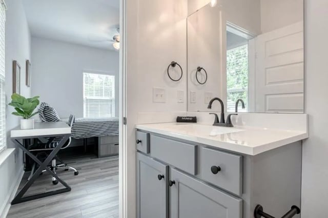 Desk plant chair and bed visible bathroom at Haven Blacksburg in Blacksburg Student Accommodation