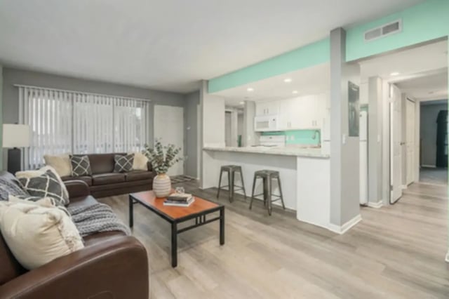 Brown sectional couch coffee table kitchen counter stools living room at Campus Hill Apartments