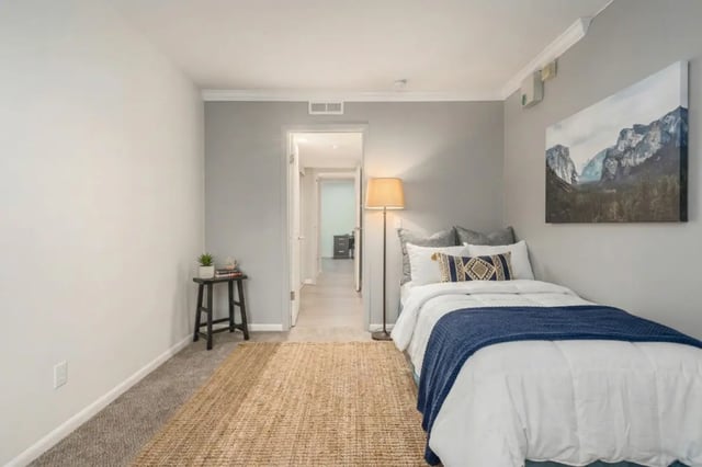 Bed with blue throw and lamp bedroom at Campus Hill Apartments