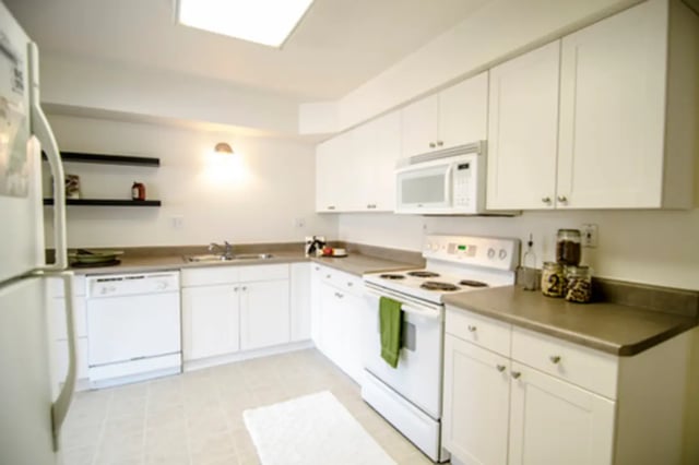 White cabinets stove microwave dishwasher kitchen at East Knolls Apartment in East Lansing Student Accommodation