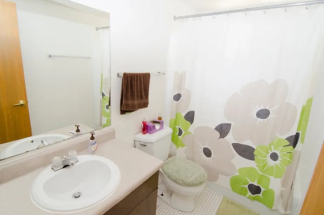 Sink toilet brown towel floral shower curtain bathroom at East Knolls Apartment in East Lansing Student Accommodation