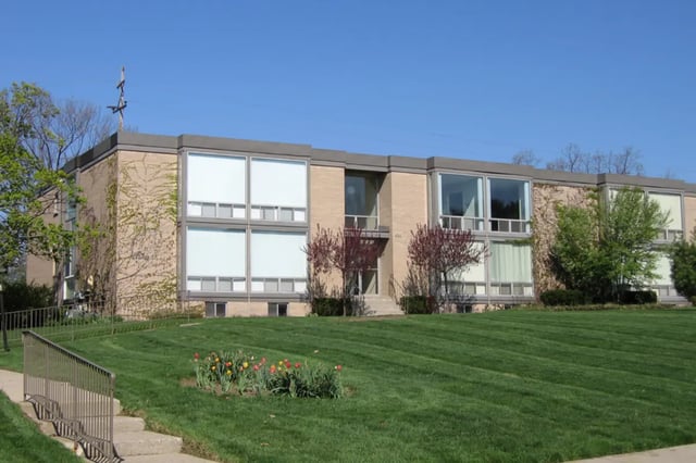 Tan building with large windows green lawn exterior at East Knolls Apartment in East Lansing Student Accommodation