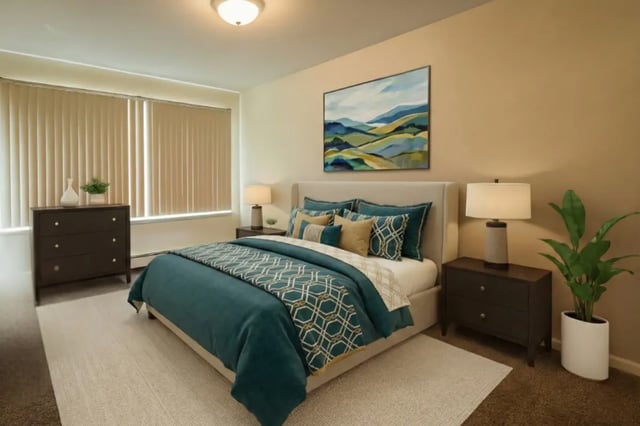 Bed with teal comforter side tables lamps artwork bedroom at Americana Apartments in East Lansing Student Accommodation