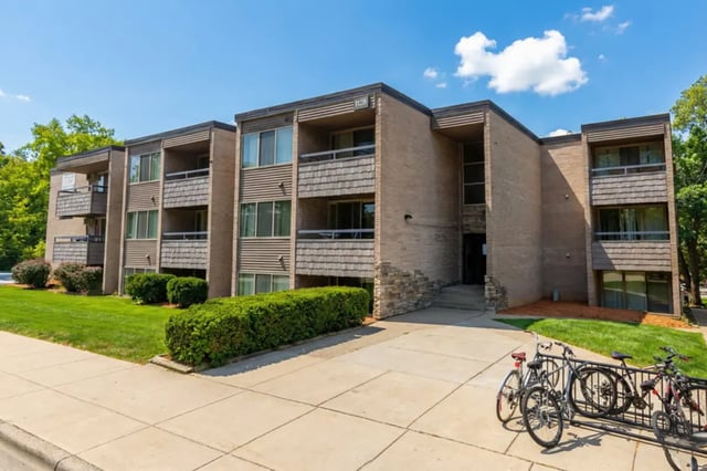 Apartment building with balconies bicycles parked exterior at Americana Apartments in East Lansing Student Accommodation