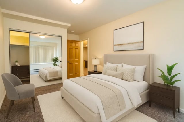 Bed dresser mirrored closet chair bedroom at Americana Apartments in East Lansing Student Accommodation