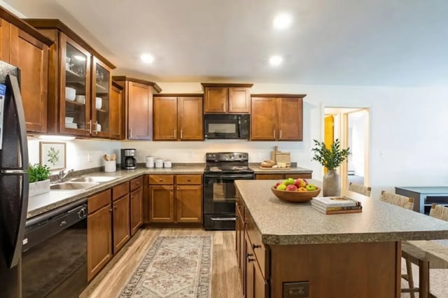 Brown wood cabinets sink stove and island kitchen at Americana Apartments in East Lansing Student Accommodation