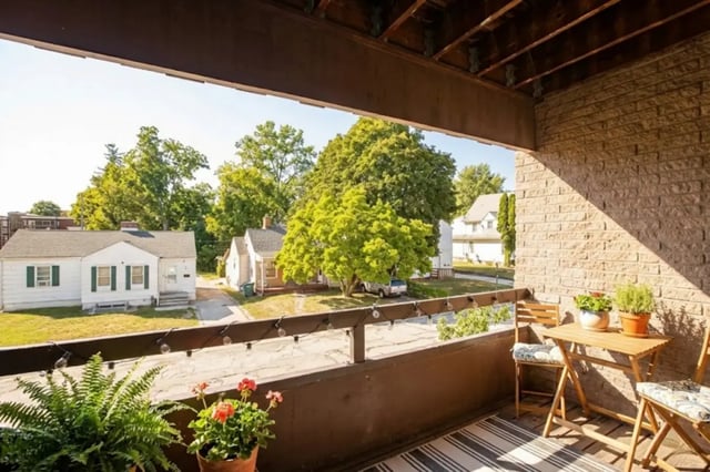 Balcony with table chairs plants and houses exterior at Americana Apartments in East Lansing Student Accommodation
