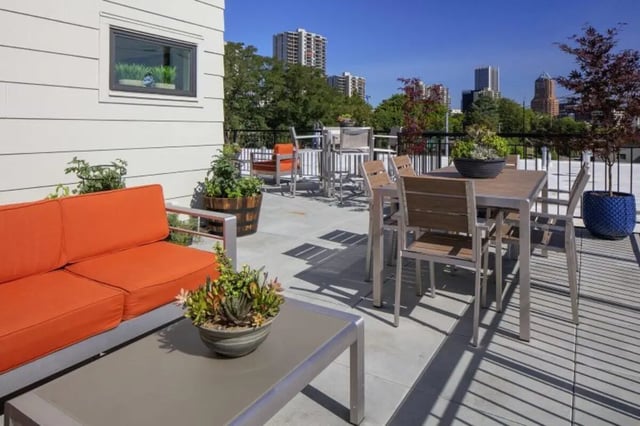 Orange couch metal tables and chairs patio exterior at Curry Court Apartments in Portland Student Accommodation