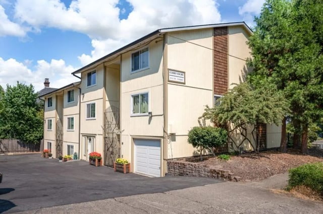 Apartment building entrance with garage and flower exterior at Curry Court Apartments in Portland Student Accommodation