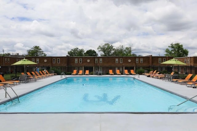 Pool with lounge chairs and umbrellas exterior at University Village Townhome Apartments in Carbondale Student Accommodation