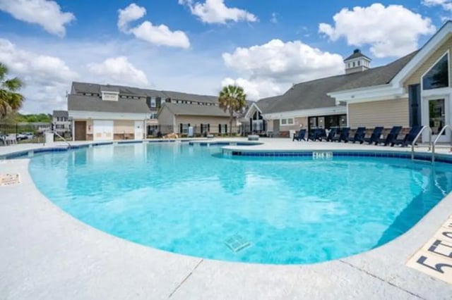 Large swimming pool with lounge chairs exterior at The Roost in Rexburg Student Accommodation