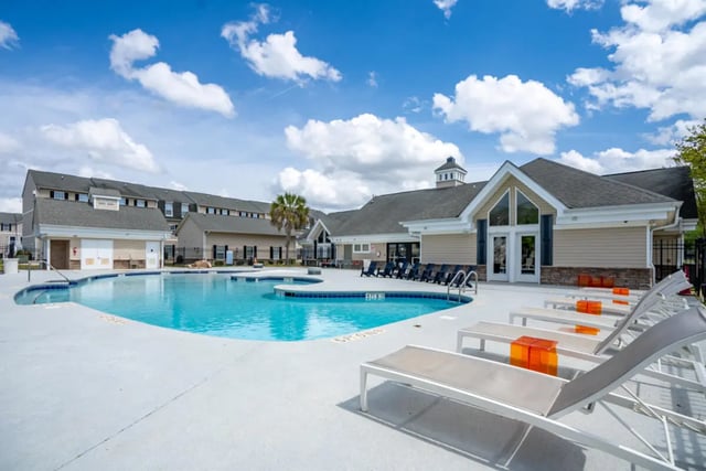 Pool lounge chairs apartment buildings exterior at The Roost in Rexburg Student Accommodation