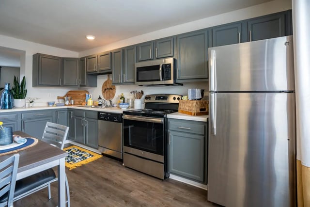 Gray cabinets stainless steel appliances kitchen area at The Roost in Rexburg Student Accommodation