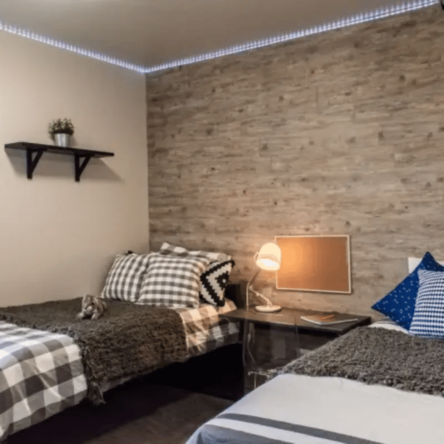Two beds with plaid blankets and pillows bedroom at Cedars Women's Housing in Rexburg Student Accommodation