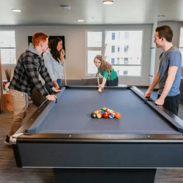 Students play billiards at a pool table playing area at Cedars Women's Housing in Rexburg Student Accommodation