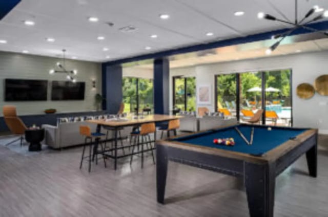 Pool table lounge with seating and TVs common area at Anthem House in Gainesville Student Accommodation
