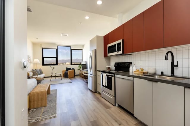 Kitchen and living area with modern furniture and large windows kitchen at Atlas House Apartments in Los Angeles Student Accommodation