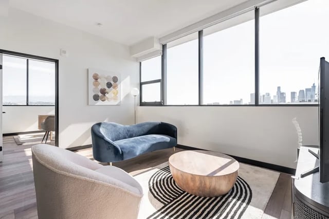 Blue sofa round coffee table rug living room at Atlas House Apartments in Los Angeles Student Accommodation