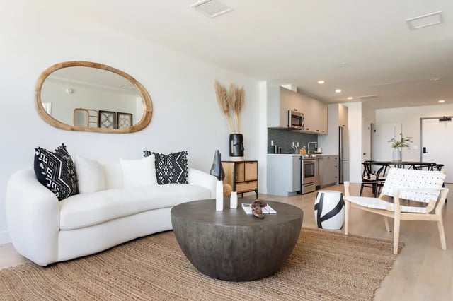 White sofa circular coffee table kitchen living area at Atlas House Apartments in Los Angeles Student Accommodation