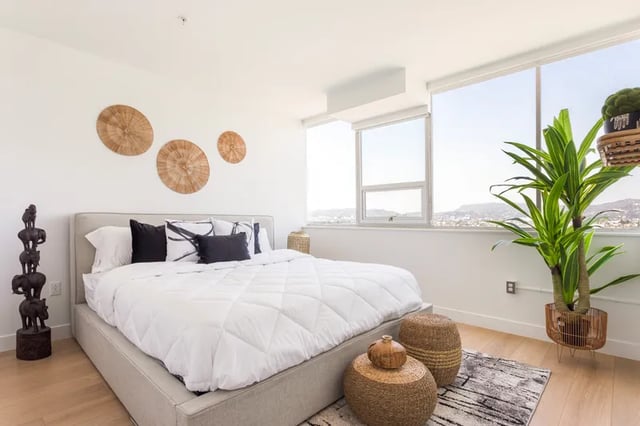 Bed with white bedding elephant statue woven decor bedroom at Atlas House Apartments in Los Angeles Student Accommodation