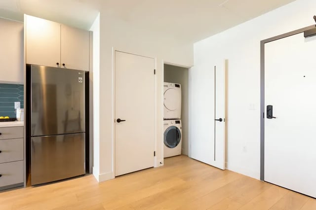 Refrigerator washer dryer stacked doors interior at Atlas House Apartments in Los Angeles Student Accommodation