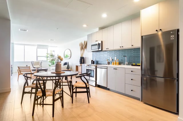 Dining table chairs refrigerator oven kitchen living room at Atlas House Apartments in Los Angeles Student Accommodation