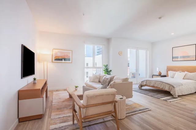Bed sofa tv and art living room interior at Atlas House Apartments in Los Angeles Student Accommodation