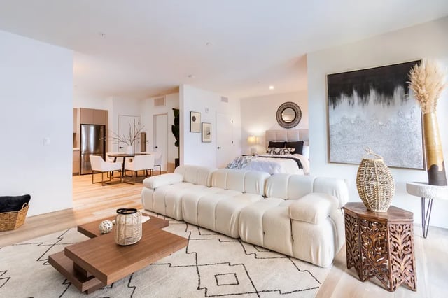 White couch coffee table rug bedroom kitchen living room at Atlas House Apartments in Los Angeles Student Accommodation