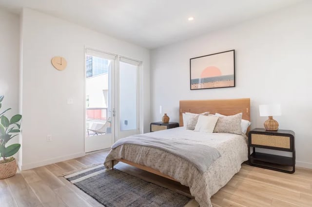 Bed nightstands artwork clock plant bedroom at Atlas House Apartments in Los Angeles Student Accommodation