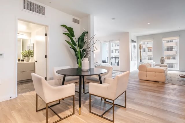 Dining table with chairs opening to living room at Atlas House Apartments in Los Angeles Student Accommodation