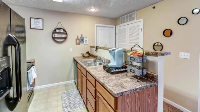 Kitchen with coffee maker sink and cabinets kitchen at 900 on Park Apartments in Carbondale Student Accommodation