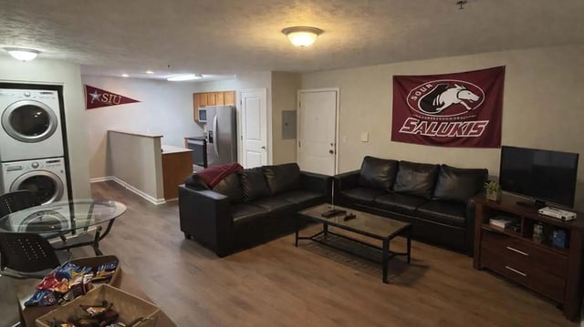 Stacked washer dryer kitchen sofas living room at 900 on Park Apartments in Carbondale Student Accommodation