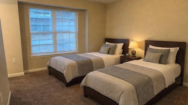 Two beds bedside table lamp bedroom at 900 on Park Apartments in Carbondale Student Accommodation