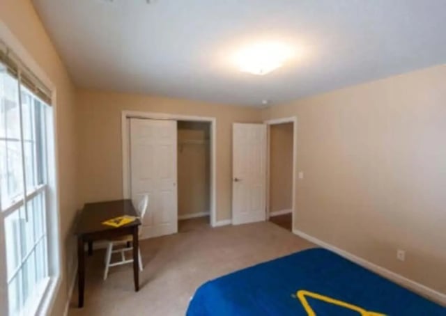 Desk chair sliding doors closet and bed bedroom at Metro Towers in Morgantown Student Accommodation