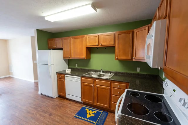 Kitchen with wood cabinets appliances and sink kitchen at Metro Towers in Morgantown Student Accommodation
