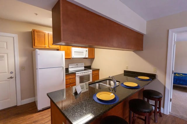 Refrigerator stove cabinets counter sink stools kitchen at Central Place in Morgantown Student Accommodation