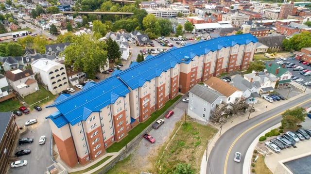 Apartment building with blue roof and cars exterior at Central Place in Morgantown Student Accommodation