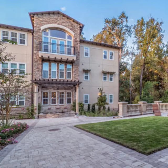 Apartment building with stone facade and green lawn exterior at Apartments Near UF in Gainesville Student Accommodation
