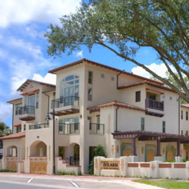 Cream stucco building with balconies Spanish exterior at Apartments Near UF in Gainesville Student Accommodation