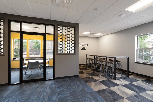Round table chairs honeycomb window communal area living room at Station 21 in West Lafayette Student Accommodation