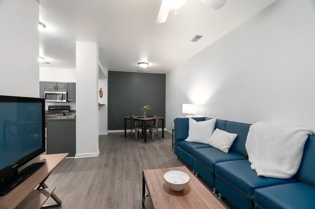 Blue sectional sofa dining table and kitchen living room at Station 21 in West Lafayette Student Accommodation