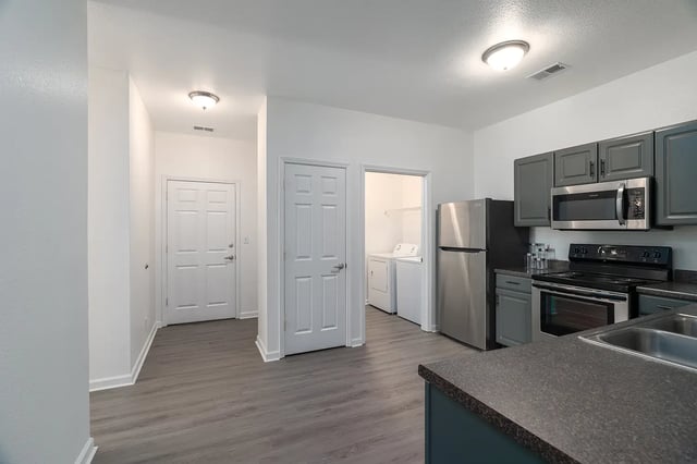 Fridge cabinets microwave stove sink laundry room kitchen at Station 21 in West Lafayette Student Accommodation