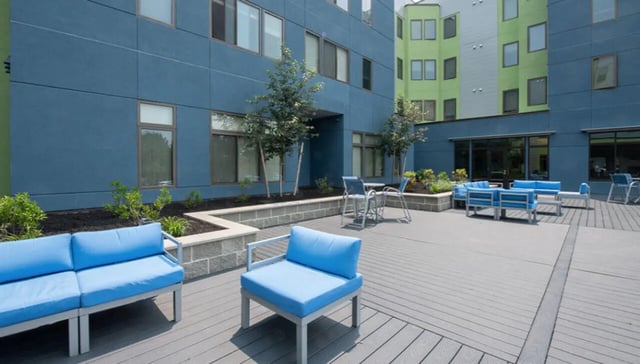 Blue outdoor seating area with modern building exterior exterior at Auden Albany in Albany Student Accommodation