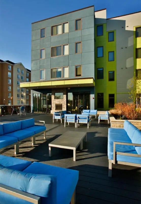 Blue couches and tables on outdoor patio exterior at Auden Albany in Albany Student Accommodation