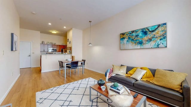 Sofa coffee table rug dining table kitchen living room at Auden Albany in Albany Student Accommodation