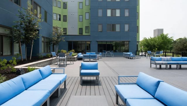 Blue sofas chairs tables outdoor common area exterior at Auden Albany in Albany Student Accommodation