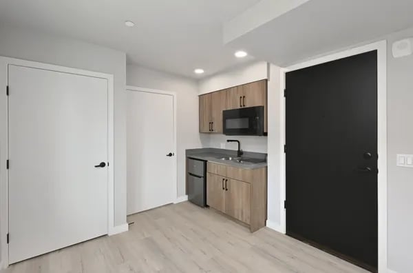 Compact kitchen with mini fridge microwave and sink kitchen at Juno Studios in Seattle Student Accommodation
