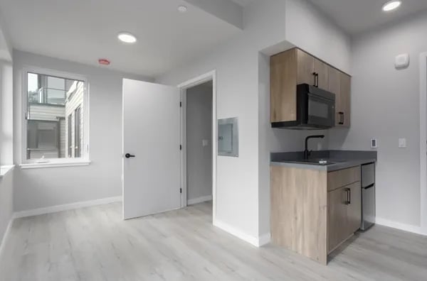 Studio apartment with open door and kitchenette kitchen at Juno Studios in Seattle Student Accommodation